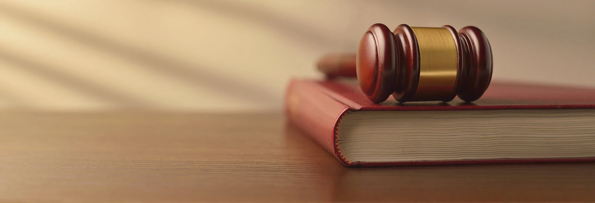Gavel and law book on a wooden desk.
